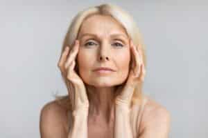 Antiage,Skincare.,Senior,Woman,Touching,Skin,Near,Eyes,And,Looking